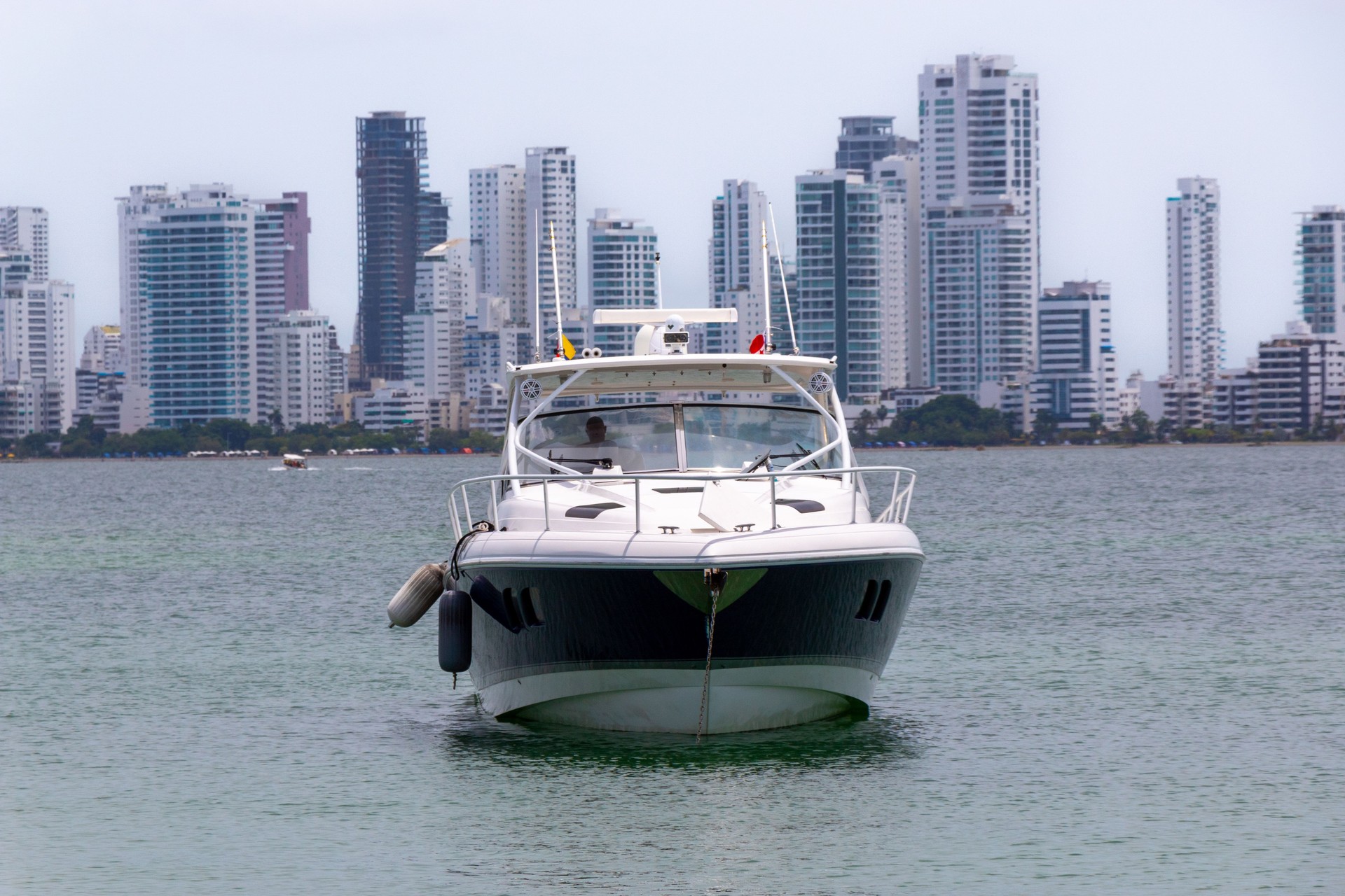 yacht in the sea with buildings in the background